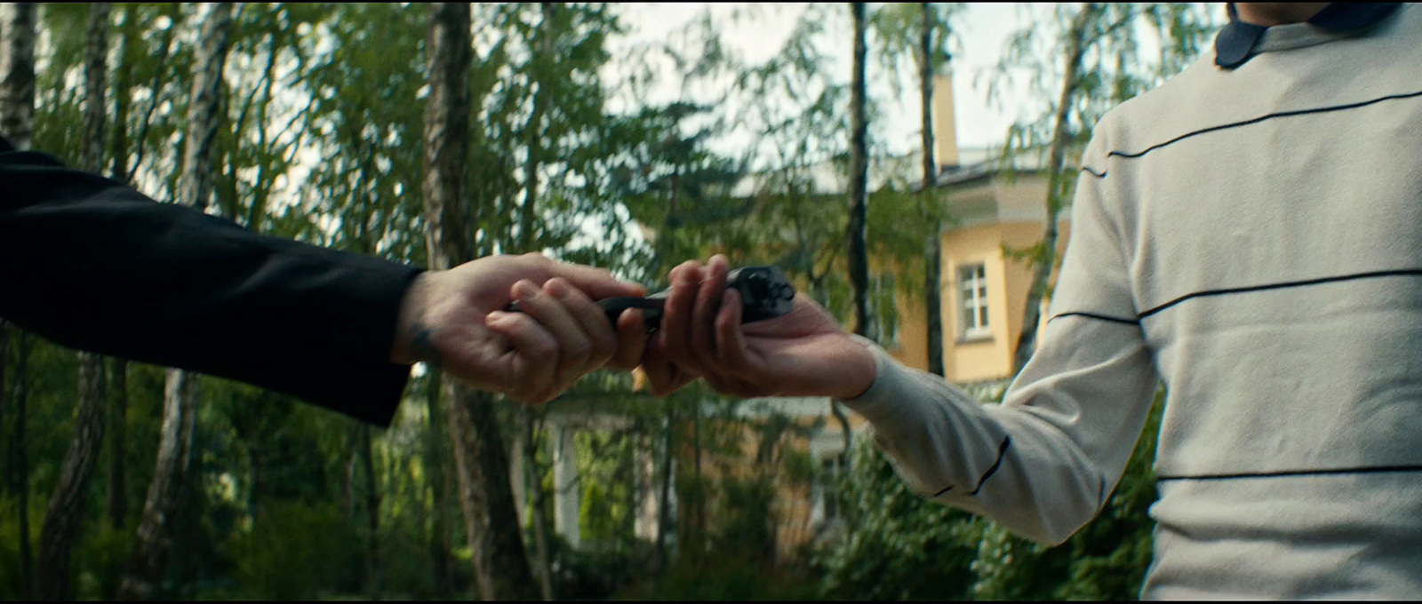 two people holding hands in front of a house