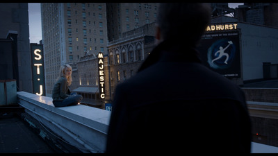 a man sitting on a ledge in front of a building