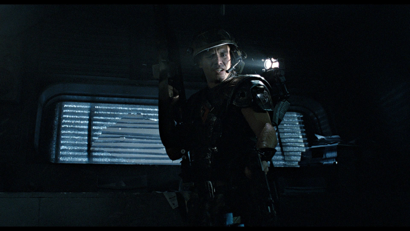 a man holding a gun in a dark room