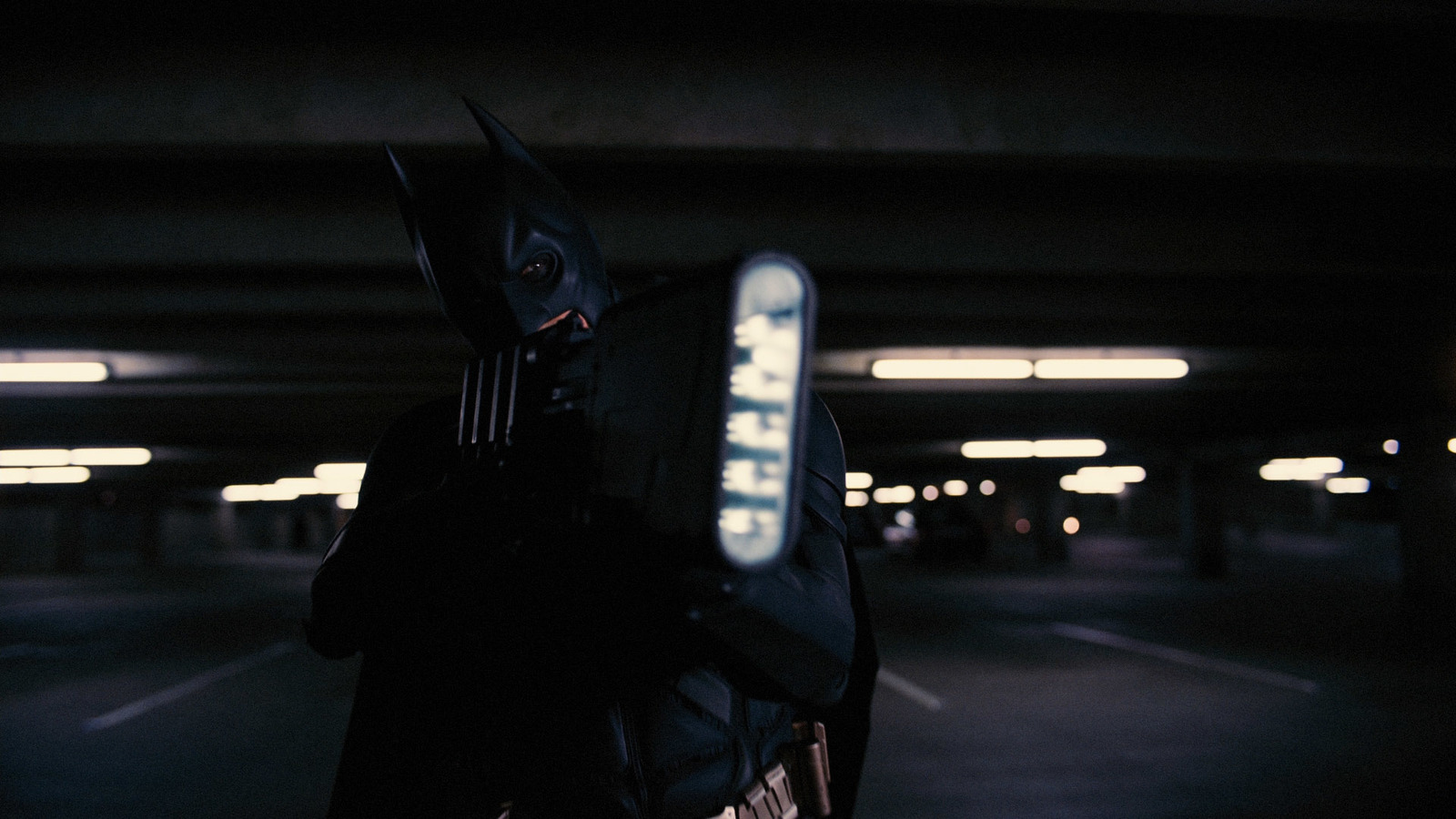 a man in a batman costume holding a cell phone