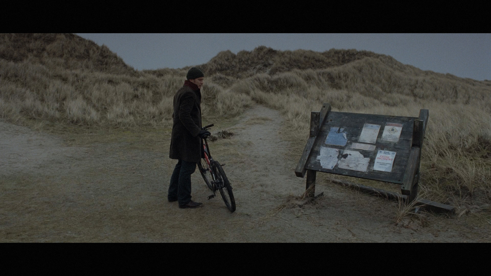 a man standing next to a bike near a sign