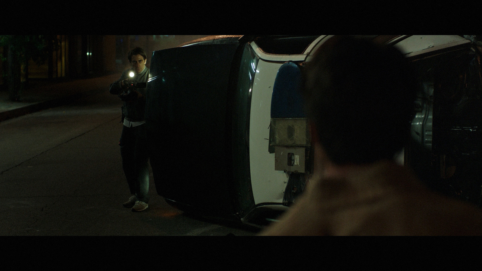 a man standing next to a black refrigerator