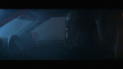 a woman sitting in a car in the dark