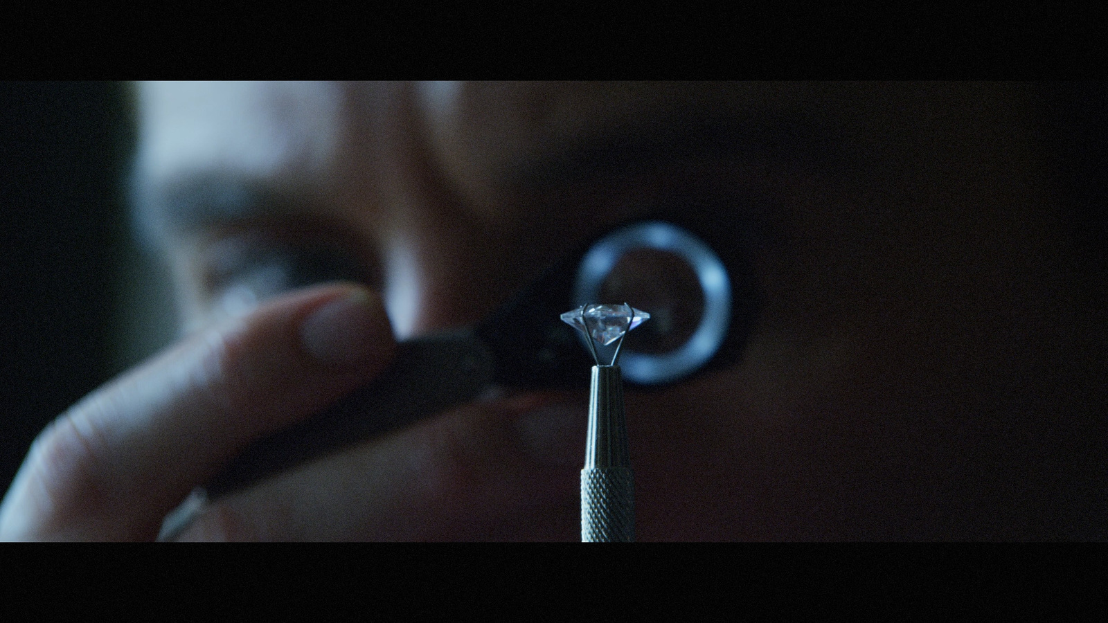 a person looking through a magnifying glass at a diamond