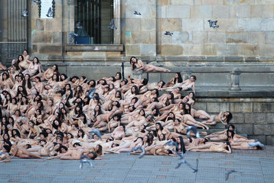 a large group of naked men sitting on the ground