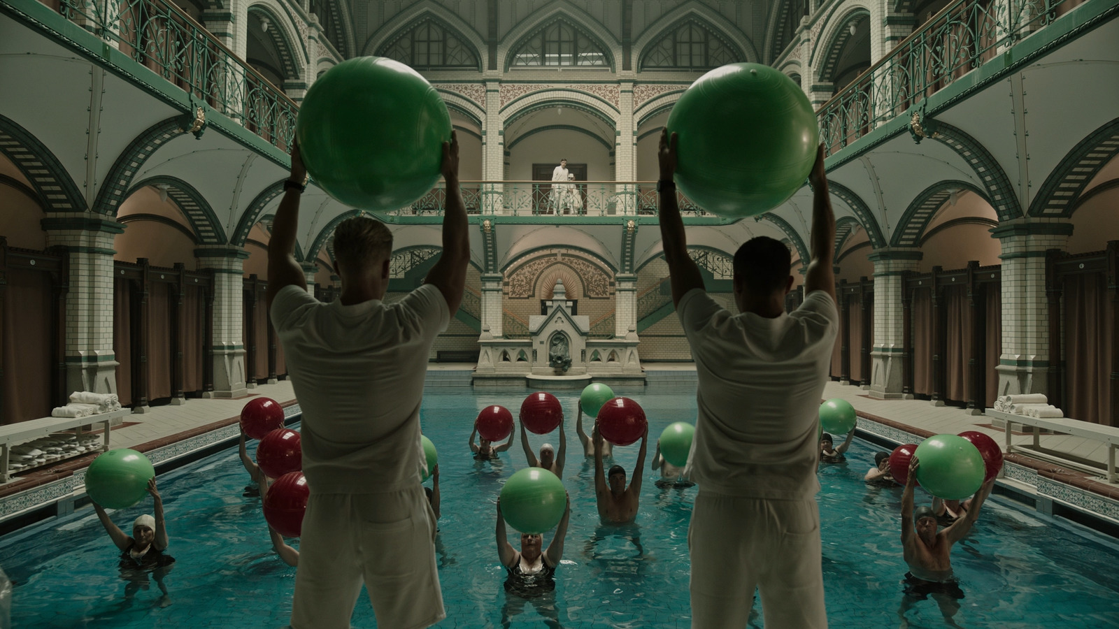 a group of men holding up large green balls