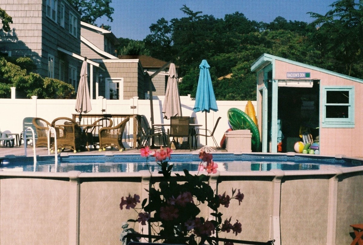 a backyard with a swimming pool and patio furniture