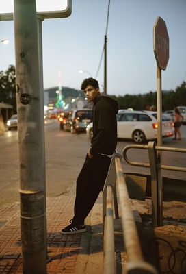 a man standing on a rail next to a street