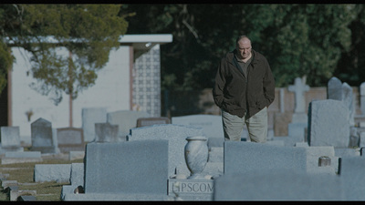 a man is walking through a cemetery