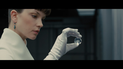 a woman wearing white gloves holding a crystal ball