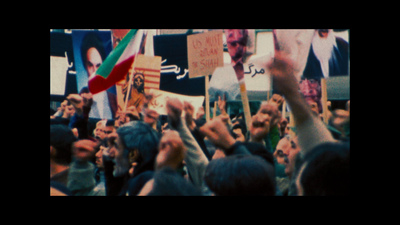 a crowd of people holding up signs and flags