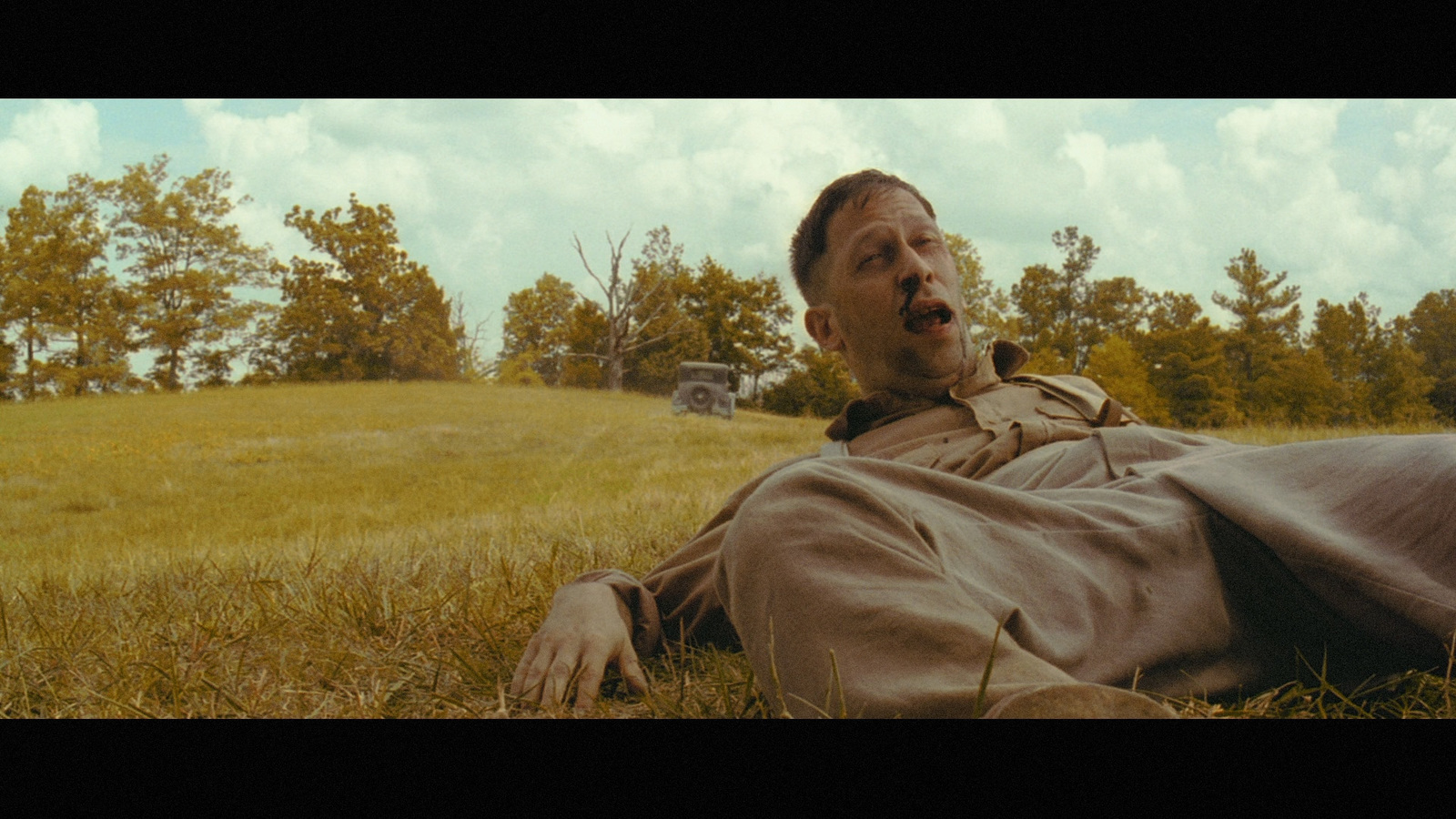 a man laying on the ground in a field