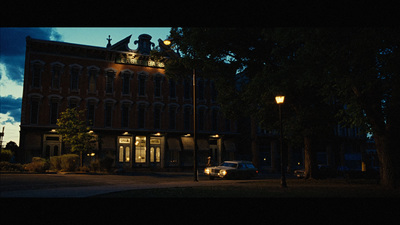 a car parked in front of a building at night