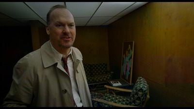 a man in a trench coat standing in a room