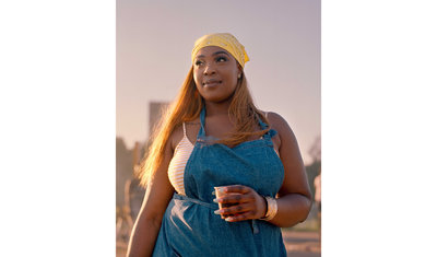 a woman in overalls holding a cup of coffee