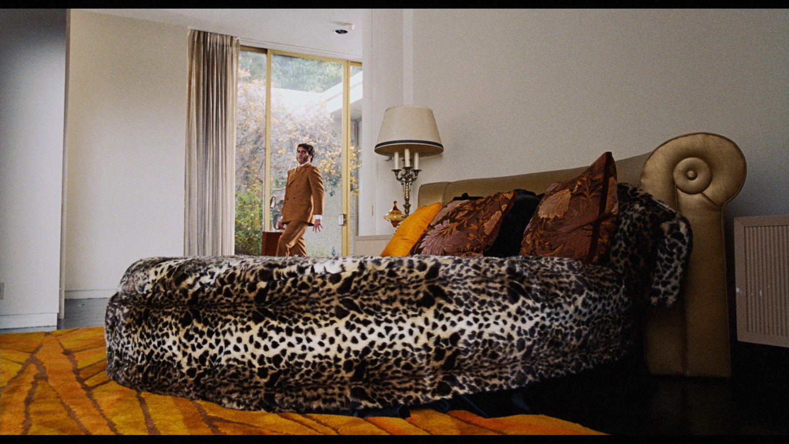 a bed with a leopard print comforter and pillows