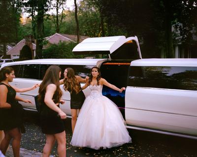 a group of women standing next to a limo