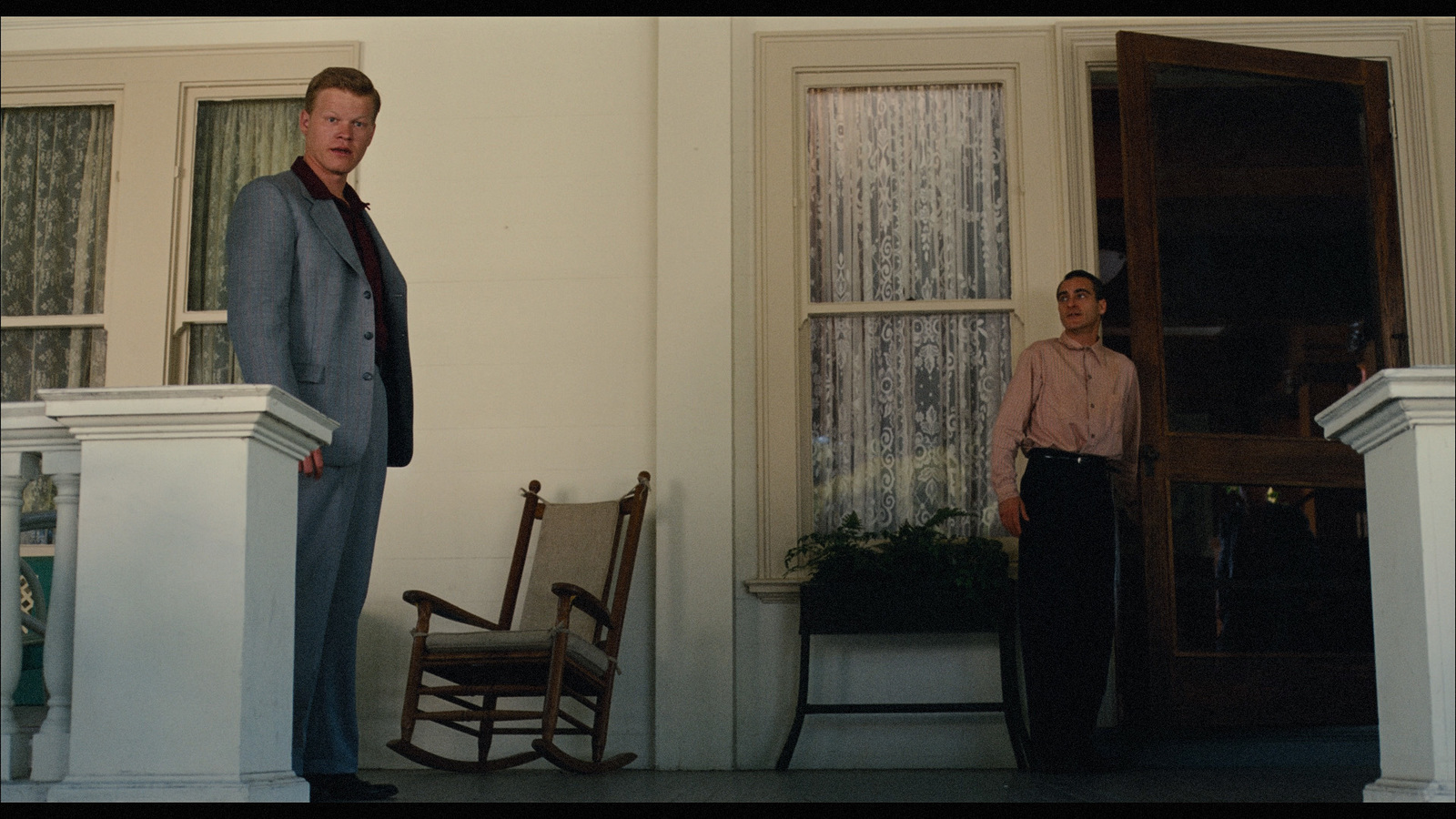 a man standing next to a woman in front of a door