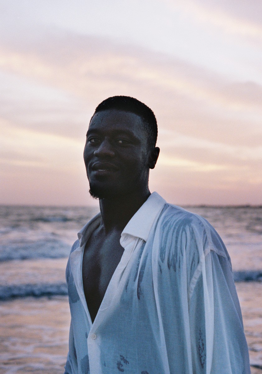 a man standing on a beach next to the ocean