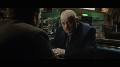 a man in a suit and tie sitting at a table