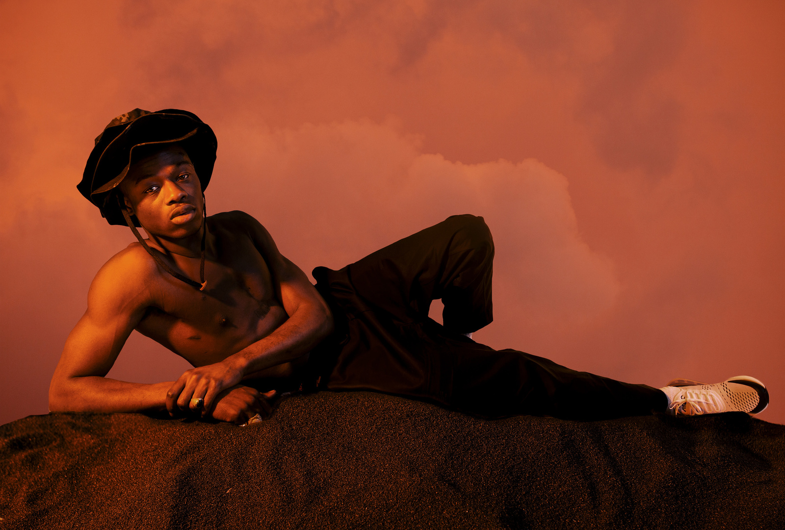 a shirtless man sitting on top of a rock