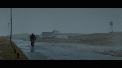 a person walking down a road in the rain