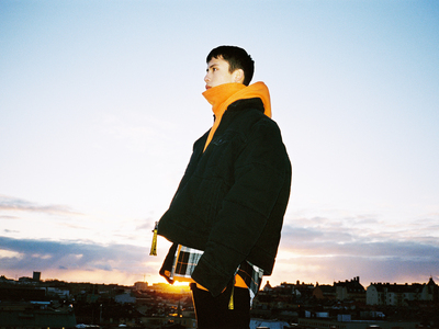 a man standing in front of a sunset