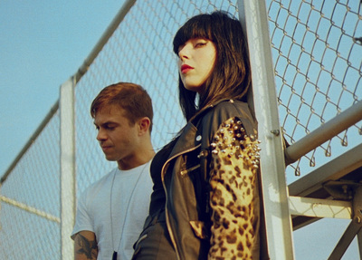 a man and a woman standing next to a fence