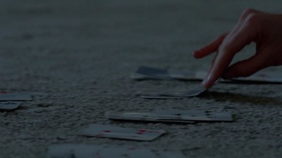 a person picking up playing cards from the floor