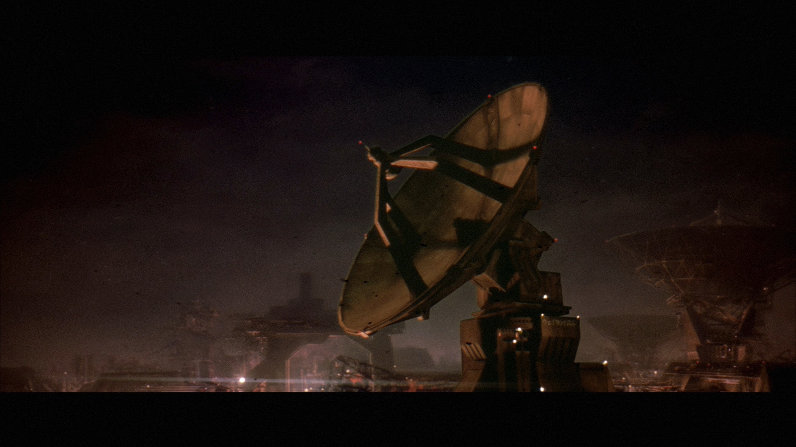 a satellite dish sitting on top of a wooden pole