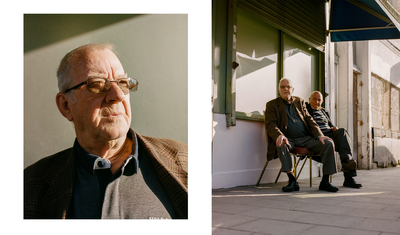 a man and woman sitting on a chair outside of a building