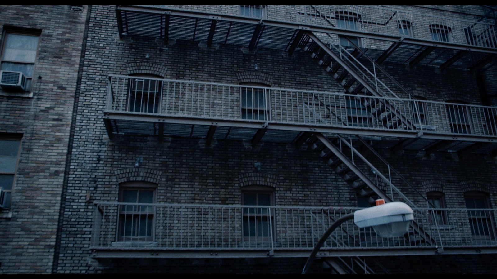 a tall brick building with a fire escape next to it