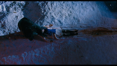 a man laying on the ground next to a pile of snow