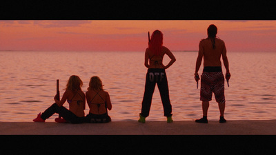 a group of people standing on top of a beach next to the ocean