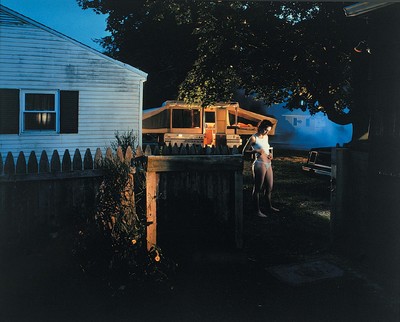 a woman standing on a porch next to a house