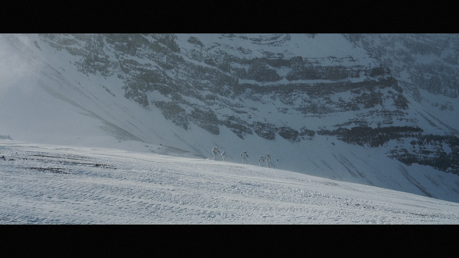 a group of people riding skis down a snow covered slope