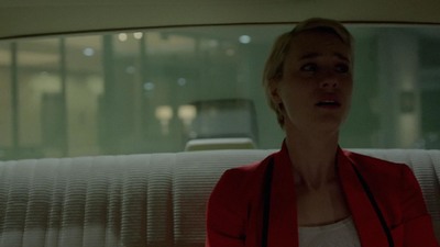 a woman in a red jacket sitting in a car