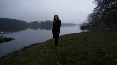 a woman standing in front of a body of water