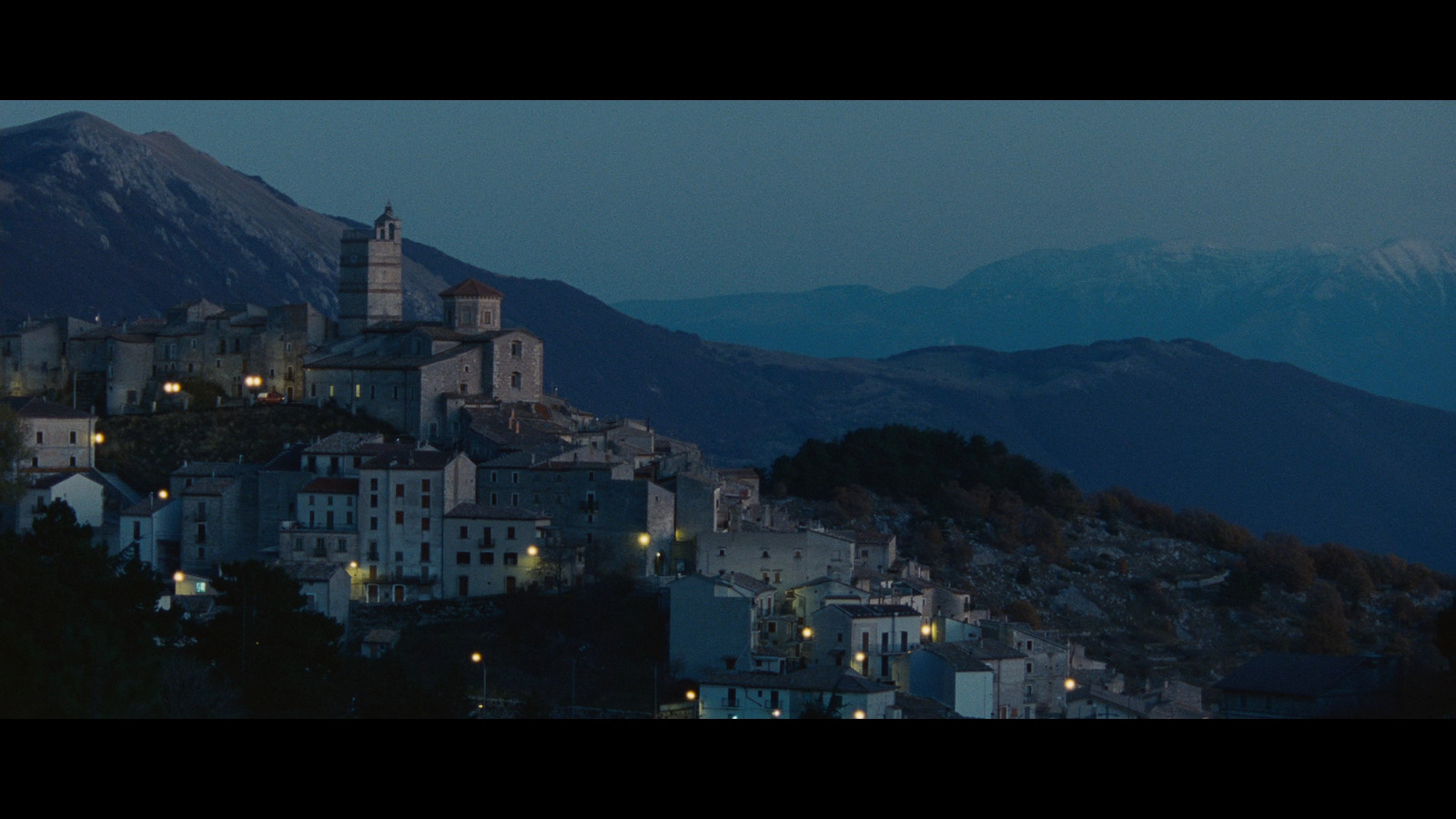 a city at night with mountains in the background