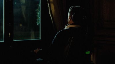 a man standing in front of a window in a dark room