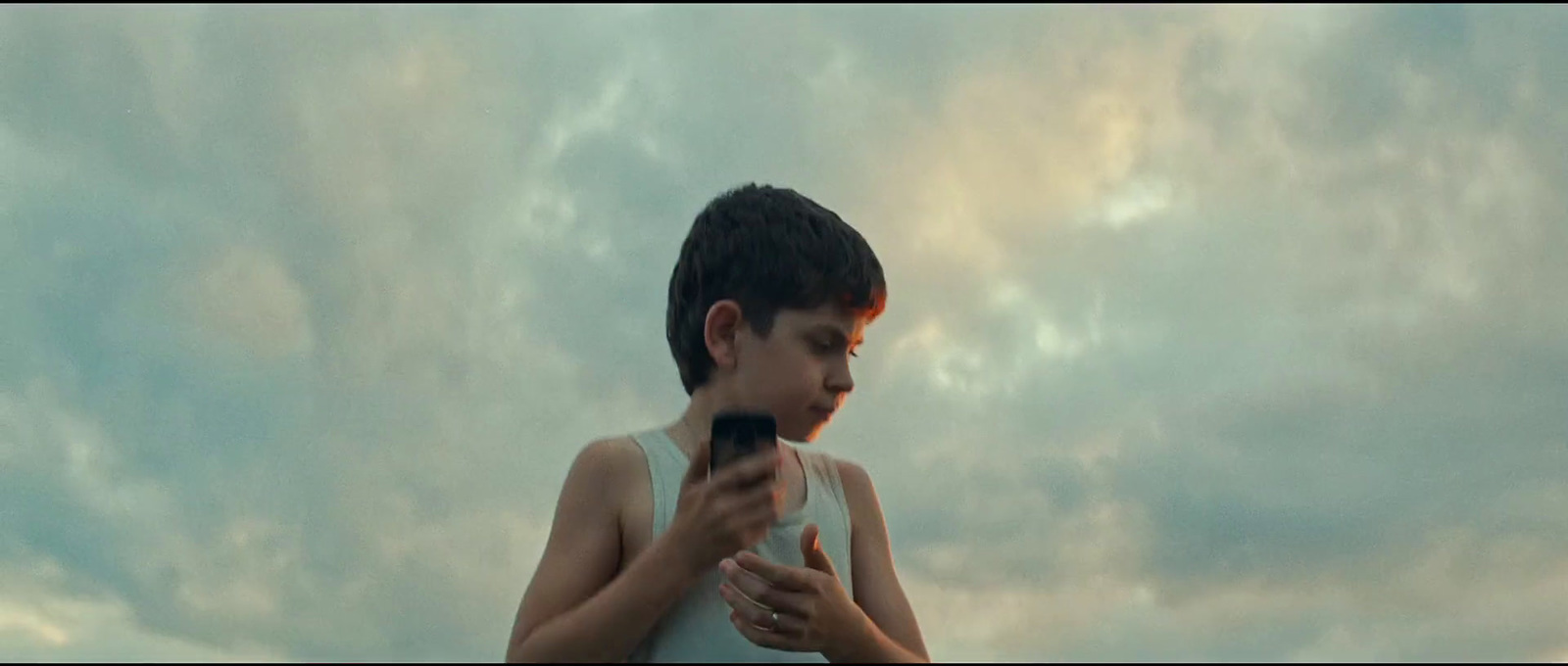 a young boy holding a cell phone in his hands