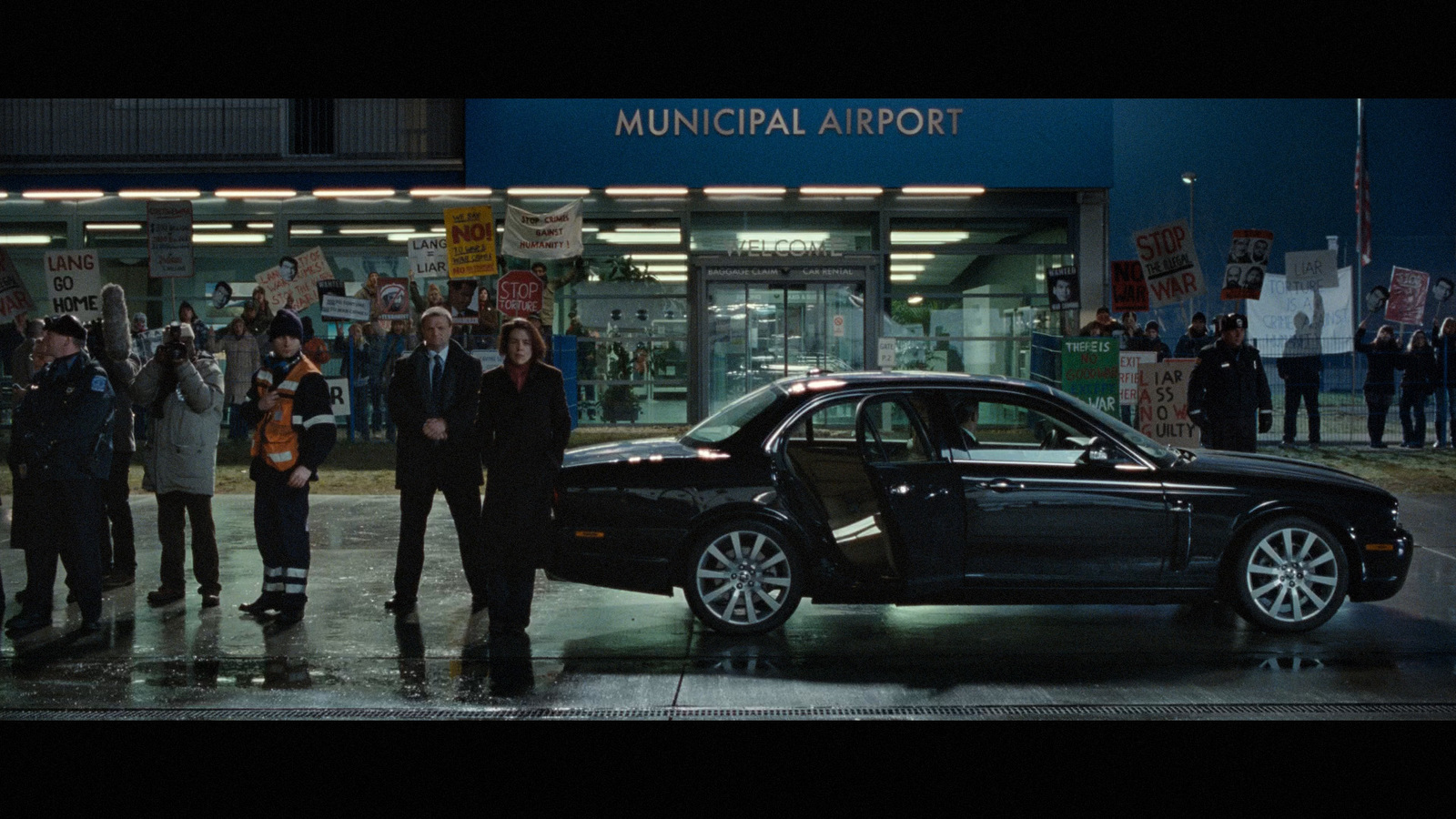 a group of people standing around a black car