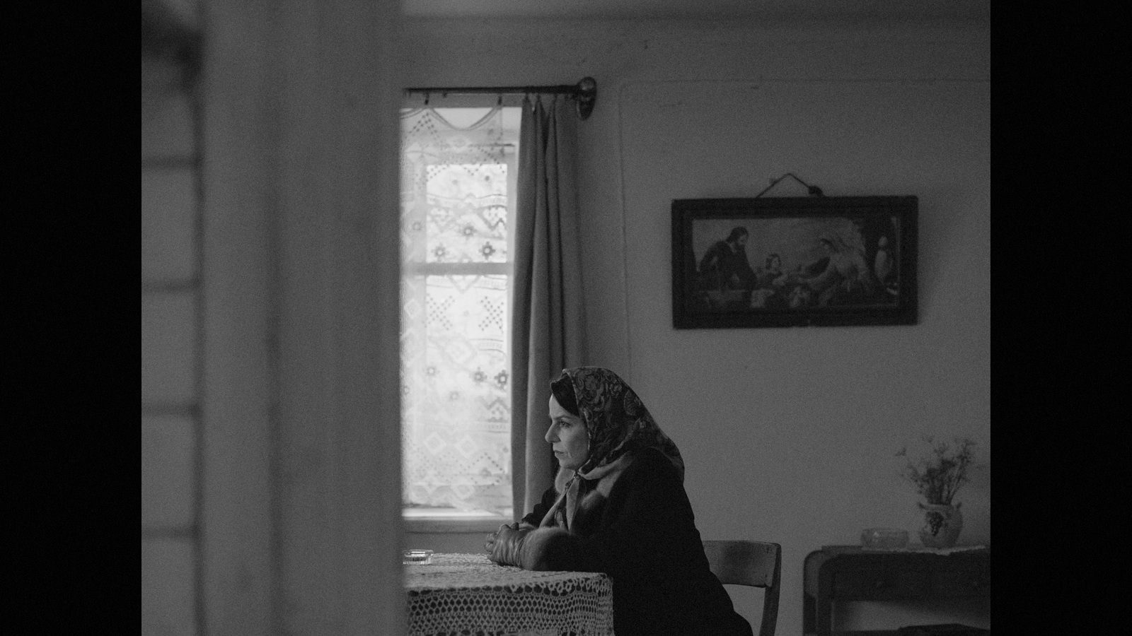 a black and white photo of a woman sitting in a chair