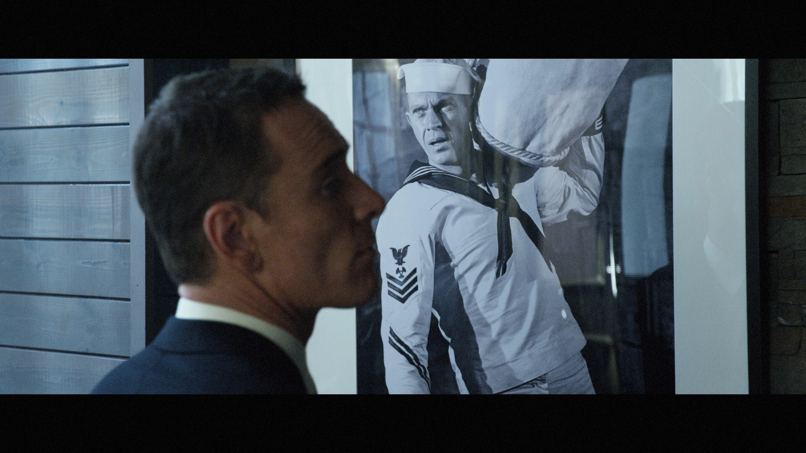 a man standing in front of a picture of a man in a suit