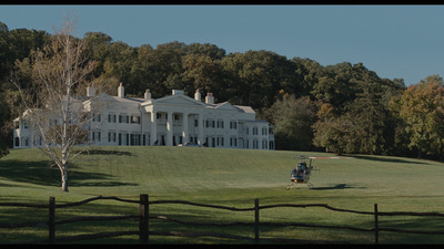 a large white house sitting on top of a lush green field