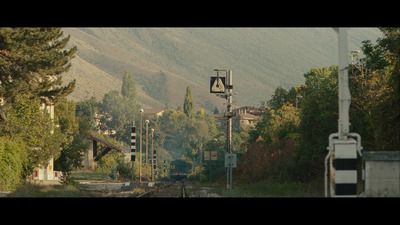 a train traveling down train tracks next to a forest