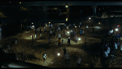 a group of people standing in a field at night