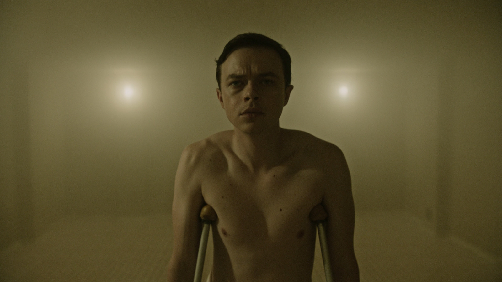 a shirtless man standing in a foggy room