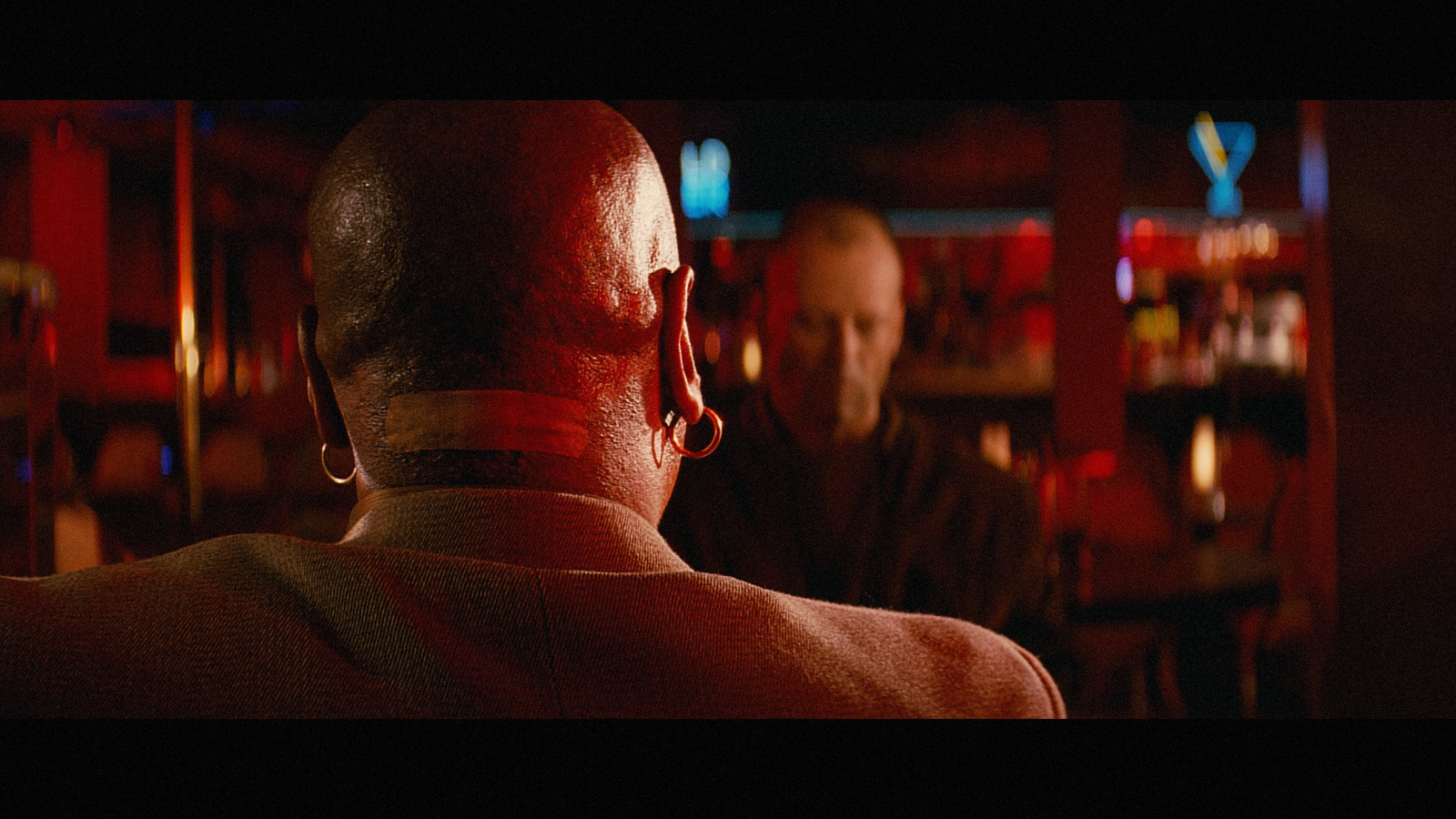 a man in a bar with another man in the background