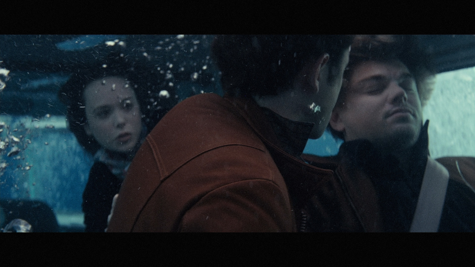 a group of people sitting in a car in the rain